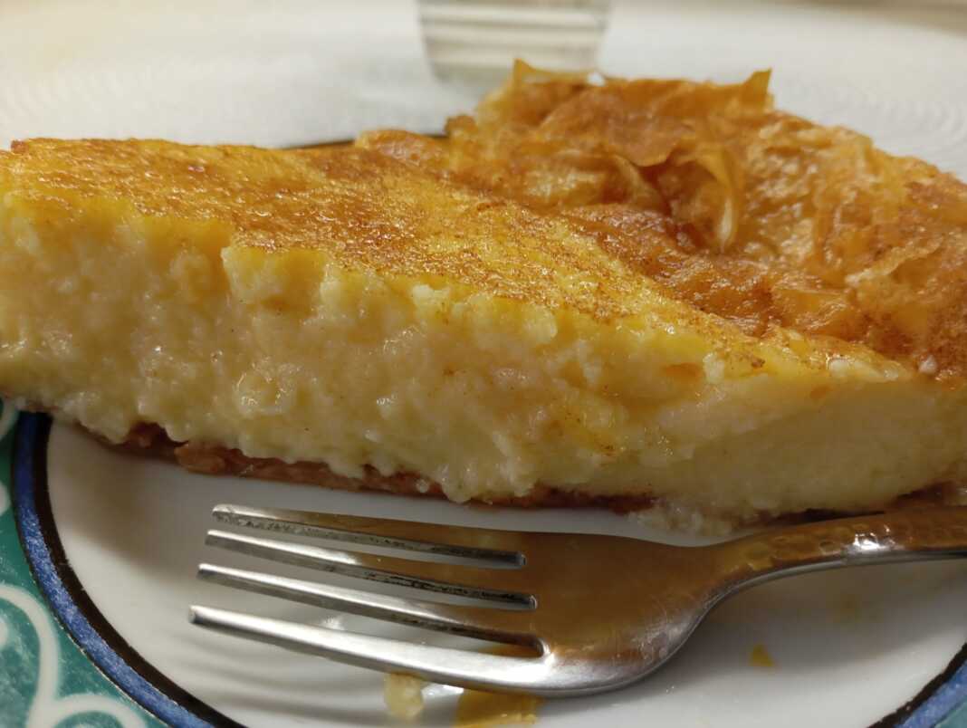 Λαχταριστή γαλατόπιτα με χρυσαφένια κρούστα σε ένα πιάτο.