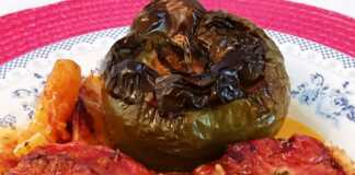 Ένα ταψί με γεμιστές ντομάτες, πιπεριές και μελιτζάνες, ανάμεσα σε κομμένες πατάτες.