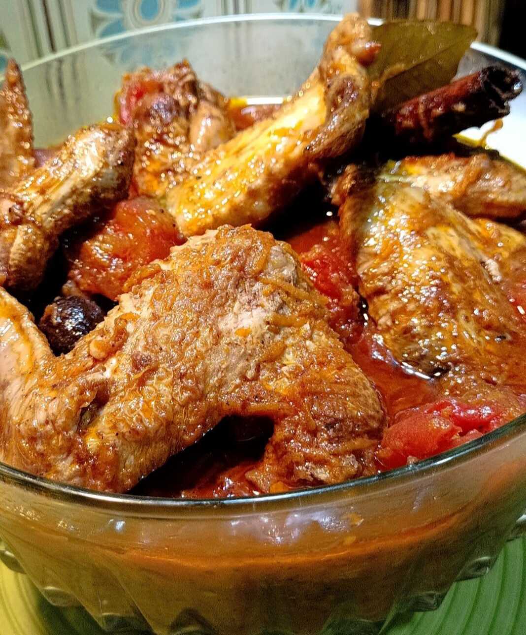 kotopoulofteroygeskokkinisto Κοτόπουλο κοκκινιστό με φτερούγες σε πιάτο, περιχυμένο με κόκκινη σάλτσα ντομάτας.