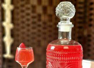 Ένα μπουκάλι γεμάτο με κόκκινο σπιτικό λικέρ φράουλας.