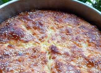 Τυρόπιτα με τσαλακωμένο φύλλο κρούστας και χρυσαφένια επιφάνεια σε ένα ταψί.