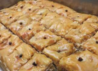 Μικρά τετράγωνα κομμάτια σιροπιασμένου μπακλαβά με ολόκληρα καρφάκια γαρύφαλλο σε παραδοσιακό δίσκο σερβιρίσματος