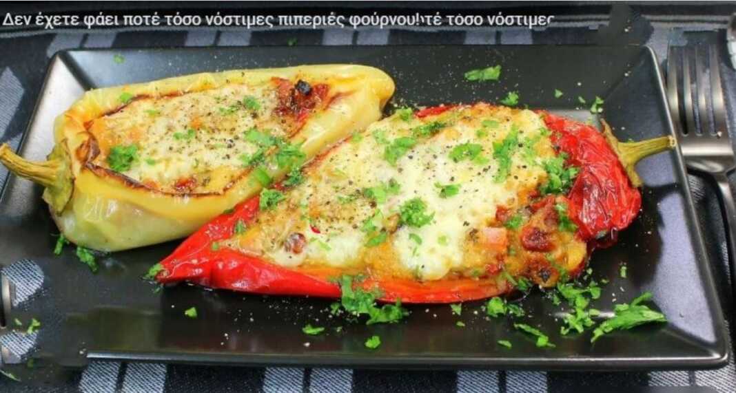 piperies fournou Ένα ταψί με γεμιστές πράσινες πιπεριές κέρατο, με κόκκινη ντομάτα και λευκό τυρί από πάνω.