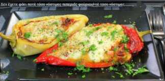 Πιπεριές γεμιστές φούρνου Ένα ταψί με γεμιστές πράσινες πιπεριές κέρατο, με κόκκινη ντομάτα και λευκό τυρί από πάνω.