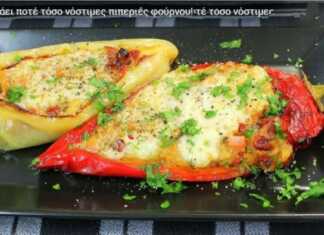 Πιπεριές γεμιστές φούρνου Ένα ταψί με γεμιστές πράσινες πιπεριές κέρατο, με κόκκινη ντομάτα και λευκό τυρί από πάνω.