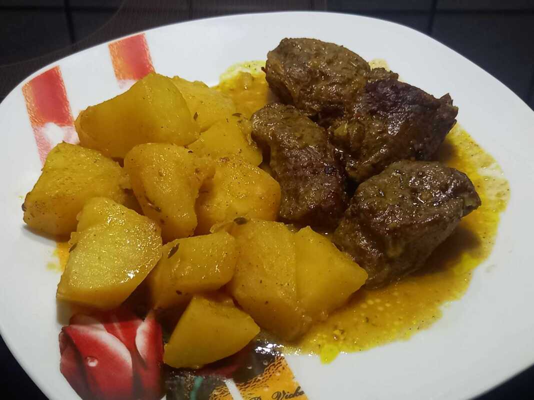 Προβατίνα στη γάστρα με πατάτες, έτοιμη για σερβίρισμα, με ζουμερό κρέας και ψημένες πατάτες.