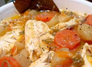 Πιάτο με ζεστή ψαρόσουπα λαβράκι, γεμάτη λαχανικά και κομμάτια ψαριού, γαρνιρισμένη με φρέσκα μυρωδικά σε ξύλινο τραπέζι.