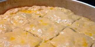 Δύο σπανακόπιτες, μία στρογγυλή μεγάλη και μερικές μικρότερες στριφτές, με χρυσαφένιο χειροποίητο φύλλο.