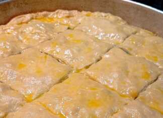 Δύο σπανακόπιτες, μία στρογγυλή μεγάλη και μερικές μικρότερες στριφτές, με χρυσαφένιο χειροποίητο φύλλο.