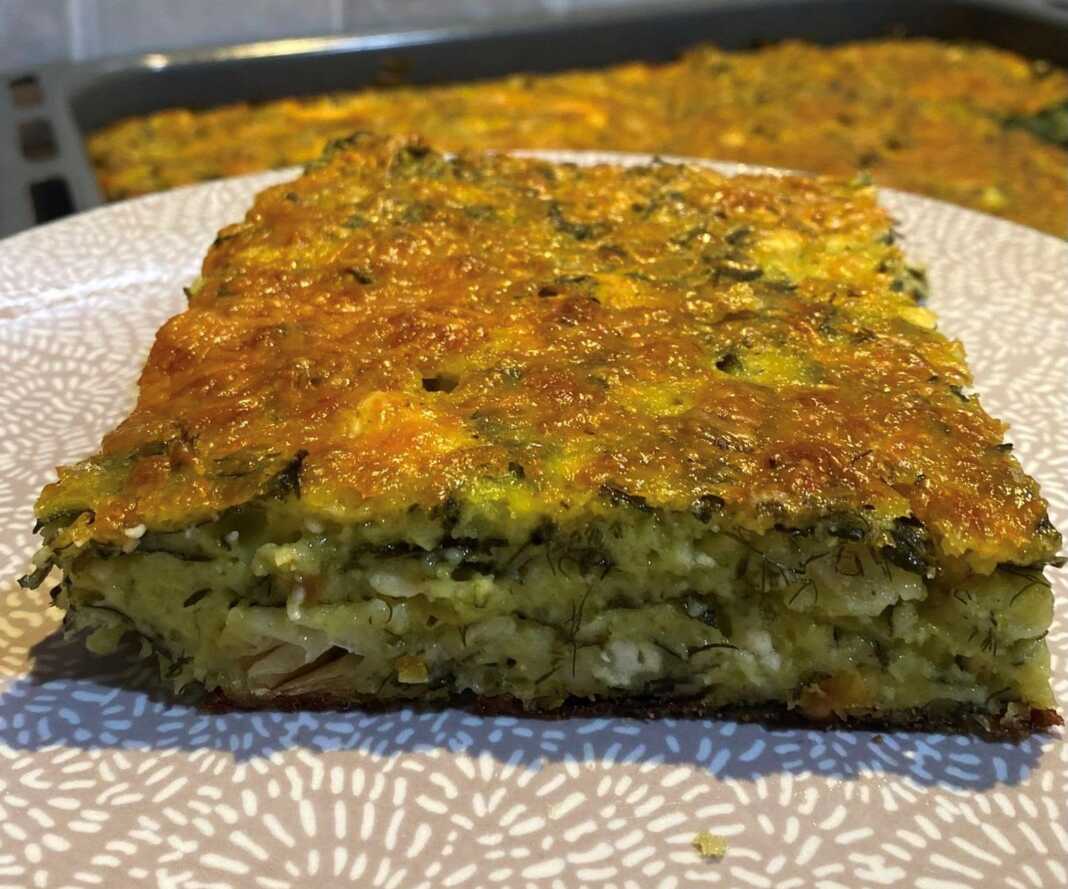 Ένα μεγάλο ταψί με χρυσαφένια σπανακοτυρόπιτα χωρίς φύλλο, έτοιμη να κοπεί.