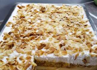 Μια στρωματοποιημένη τούρτα αμυγδάλου με λευκή κρέμα, πασπαλισμένη με αμύγδαλα φιλέ.