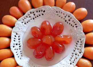 Γυάλινο βάζο με λαμπερά, ολόκληρα κουμ κουάτ γλυκό του κουταλιού, μέσα σε διαυγές σιρόπι.