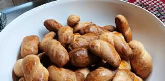 Ένα μπωλ με χρυσαφένια Κουλουράκια μαστίχας σε διάφορα σχέδια, αλειμμένα με αυγό.