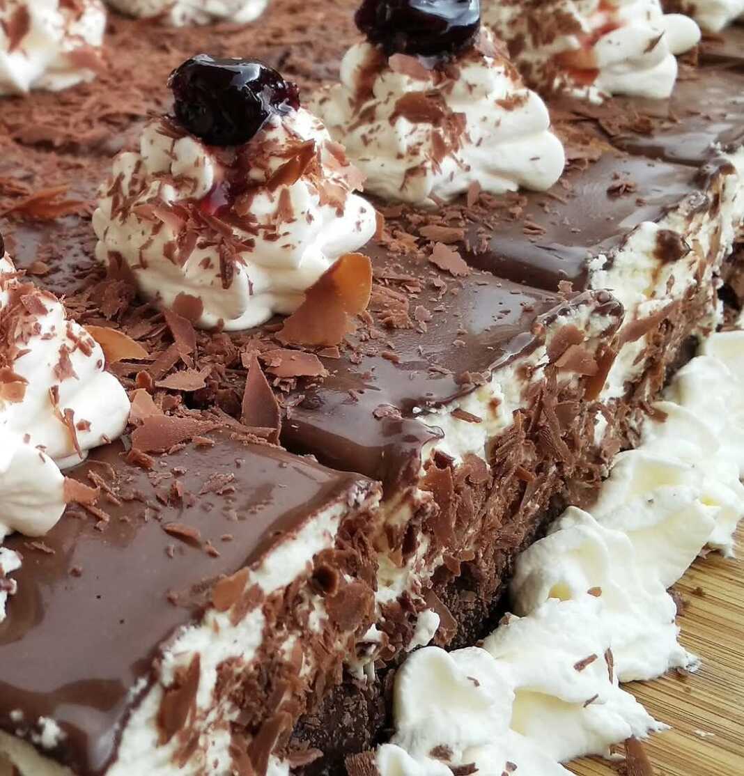 Ένα κομμάτι πάστας ταψιού Μπλακ Φόρεστ με στρώσεις σοκολάτας, κρέμας, βύσσινου και γκανάζ.