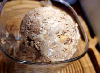 Κρεμώδες σπιτικό παγωτό μόκα σε ένα μπολ, πασπαλισμένο με θρυμματισμένα μπισκότα και φουντούκια.