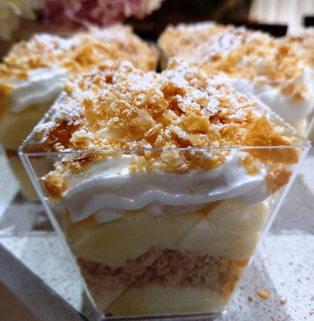 atomika milfeig1 Ατομικό μιλφέιγ σε ποτήρι με στρώσεις κρέμας, θρυμματισμένων μπισκότων και σαντιγί, πασπαλισμένο με άχνη ζάχαρη.