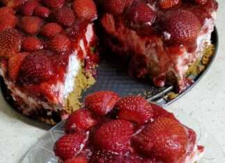 Ένα λαχταριστό τσιζκέικ φράουλα στολισμένο με φρέσκες κομμένες φράουλες.