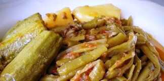 Ένα πιάτο με φρέσκα φασολάκια, πατάτες και κολοκυθάκια σιγομαγειρεμένα σε κόκκινη σάλτσα, γαρνιρισμένο με φρέσκο ελαιόλαδο και φέτα.