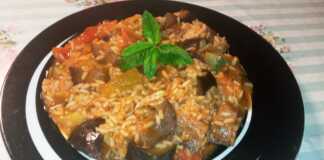 Ένα πιάτο με λαχανικά (μελιτζάνα, κολοκύθι, πιπεριά, ντομάτα) και ρύζι σε κόκκινη σάλτσα, πασπαλισμένο με φρέσκο δυόσμο.