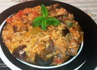 Ένα πιάτο με λαχανικά (μελιτζάνα, κολοκύθι, πιπεριά, ντομάτα) και ρύζι σε κόκκινη σάλτσα, πασπαλισμένο με φρέσκο δυόσμο.