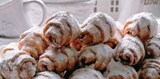 Φρεσκοψημένα κρουασανακια πασπαλισμένα με άχνη ζάχαρη σε ένα πιάτο