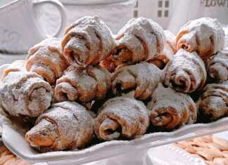 Φρεσκοψημένα κρουασανακια πασπαλισμένα με άχνη ζάχαρη σε ένα πιάτο