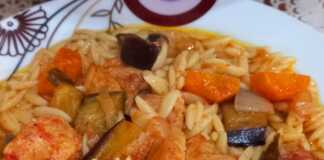 Ένα πιάτο με χοιρινό κρέας, κριθαράκι και κομμάτια μελιτζάνας σε πλούσια σάλτσα.