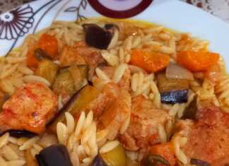 Ένα πιάτο με χοιρινό κρέας, κριθαράκι και κομμάτια μελιτζάνας σε πλούσια σάλτσα.