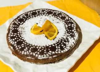 Μια στρογγυλή τορτα καπρέζε πασπαλισμένη με άχνη ζάχαρη.