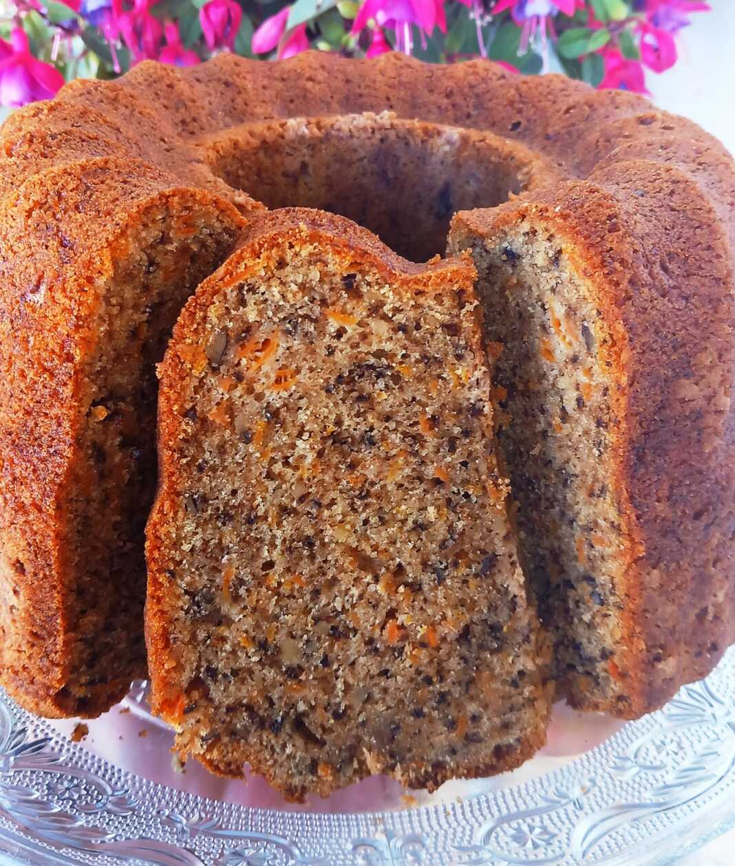 Ένα κομμάτι κέικ καρότου με καρύδια, πασπαλισμένο προαιρετικά με ζάχαρη