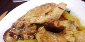 Μαγειρεμένο στήθος κοτόπουλου λεμονάτο σε κατσαρόλα, γαρνιρισμένο με φέτες λεμονιού και φρέσκα μυρωδικά.