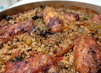 Ένα ταψί με ψημένο κοτόπουλο (φτερούγες) πάνω από αφράτο ρύζι με λαχανικά.