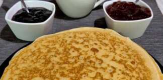 Σωρός από χρυσαφένιες κρέπες αλειμμένες με βούτυρο, έτοιμες για σερβίρισμα με μαρμελάδα.