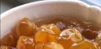 Ένα γυάλινο μπολ γεμάτο με λαμπερά, κεχριμπαρένια λευκά κεράσια σε παχύρρευστο σιρόπι.