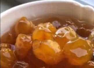 Ένα γυάλινο μπολ γεμάτο με λαμπερά, κεχριμπαρένια λευκά κεράσια σε παχύρρευστο σιρόπι.