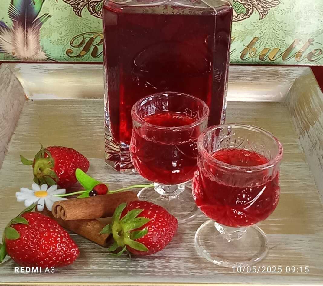 liker_fraoulas0 Ένα μπουκάλι γεμάτο με κόκκινο σπιτικό λικέρ φράουλας.