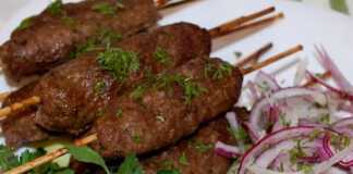 Μακρόστενα Κεμπαπ φούρνου περασμένα σε ξυλάκια σουβλακιού, ψημένα σε ένα ταψί στρωμένο με λαδόκολλα.