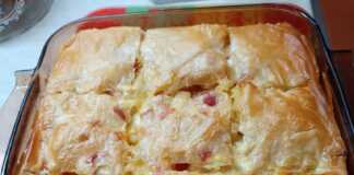 Ένα ταψί με χρυσαφένια, κομμένη σε μερίδες μακαρονόπιτα με φύλλο κρούστας.