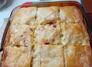 Ένα ταψί με χρυσαφένια, κομμένη σε μερίδες μακαρονόπιτα με φύλλο κρούστας.