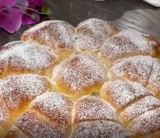 Μια ολόκληρη αφράτη μηλόπιτα με χρυσαφένια κρούστα χωρισμένη σε εννέα πανέμορφα κομμάτια πασπαλισμένη με άχνη ζάχαρη