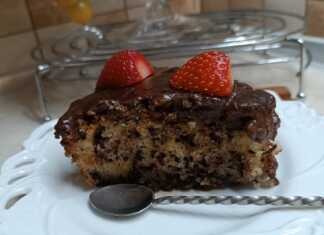 Ένα κομμάτι μυρμήγκατο σε πιατέλα, ένα κέικ σιροπιασμένο με γλάσο σοκολάτας και φρέσκιες φράουλες στην κορυφή.