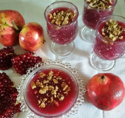 mous rodiou Κρεμώδης μους ροδιού σε μπολ, στολισμένη με καρύδια και σπόρους ροδιού.