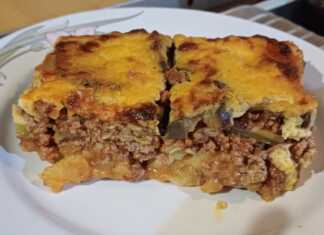 Δύο κομμάτια χρυσαφένιο μουσακά, όπου διακρίνονται οι στρώσεις λαχανικών και κιμά, με μια παχιά κρούστα μπεσαμέλ από πάνω.