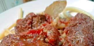 Πιάτο με ζουμερή κερκυραϊκή παστιτσάδα και χοντρά μακαρόνια, πασπαλισμένο με τριμμένο τυρί.