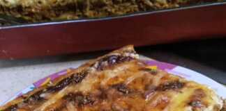 Ένα λαχταριστό ταψί με παστιτσάρα, έτοιμο να σερβιριστεί, με χρυσαφένια κρούστα μπεσαμέλ και τριμμένο τυρί.