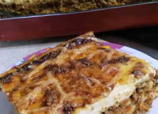 Ένα λαχταριστό ταψί με παστιτσάρα, έτοιμο να σερβιριστεί, με χρυσαφένια κρούστα μπεσαμέλ και τριμμένο τυρί.