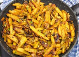 Πώς να μαγειρέψετε πατάτες με μανιτάρια σε ένα τηγάνι: σαν επαγγελματίας Ένα τηγάνι με χρυσαφένιες τηγανητές πατάτες ανακατεμένες με σωταρισμένα μανιτάρια και φέτες κρεμμυδιού.