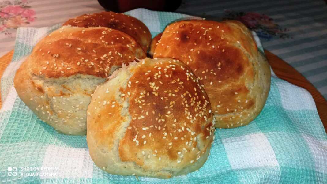 Ένα ταψί με μικρά, στρογγυλά, χρυσαφένια ψωμάκια φτιαγμένα με κουτάλα.