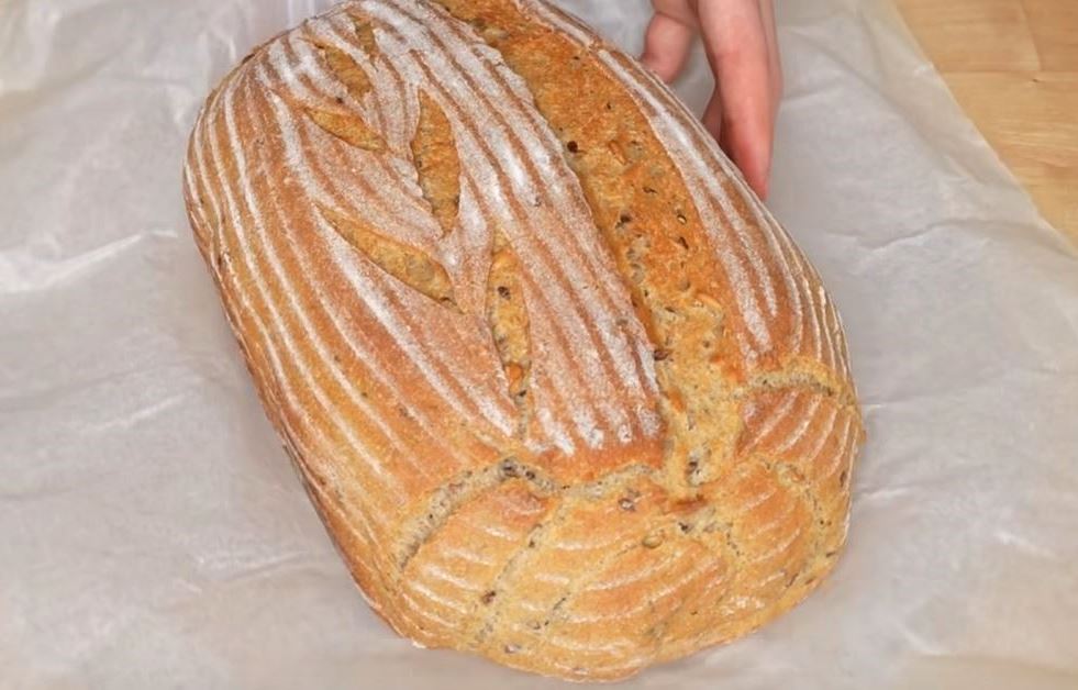 Φρεσκοψημένο ψωμί σίτου-σίκαλης με σπόρους μέσα σε μια γάστρα.