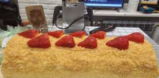 Φωτογραφία με ρολό παντεσπάνι γεμιστό με φράουλες και κρέμα γιαουρτιού.